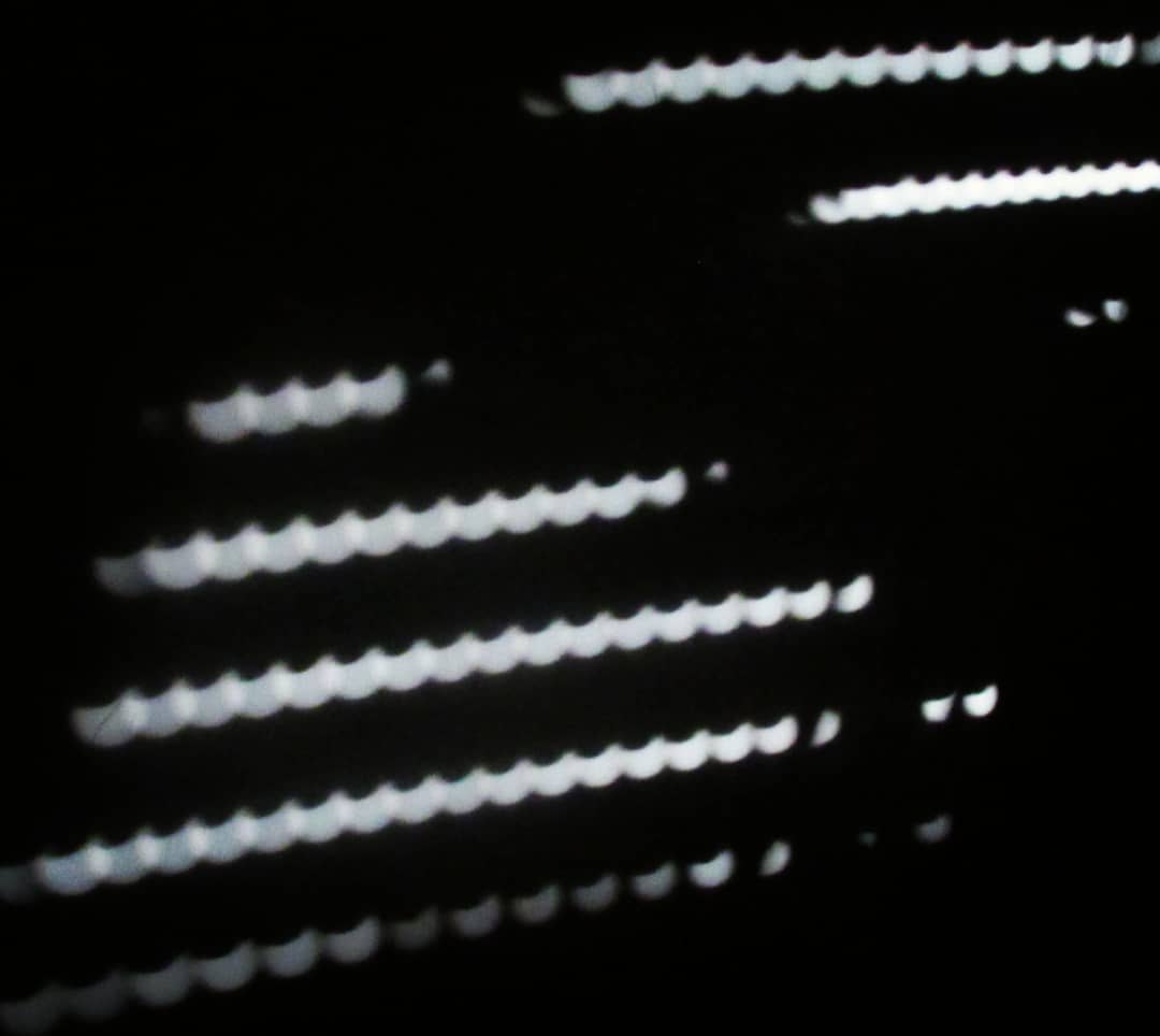 Hileras diagonales de puntos de luz blanca sobre negro